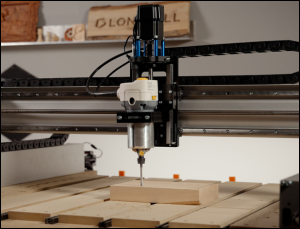 LongMill MK3 2 | Sienci Labs CNC router with spindle cutting a small wooden block on a worktable.
